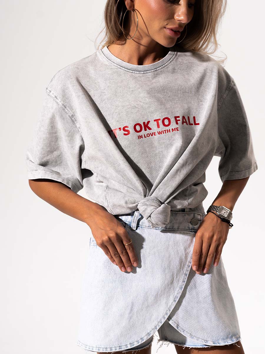 The t-shirt is in light gray color with the print It's OK to fall