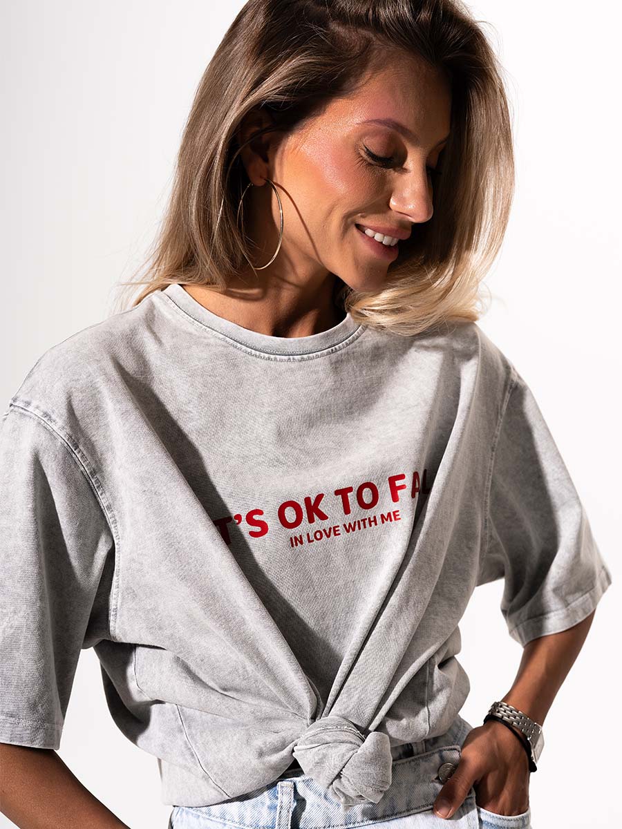 The t-shirt is in light gray color with the print It's OK to fall