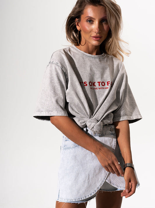 The t-shirt is in light gray color with the print It's OK to fall