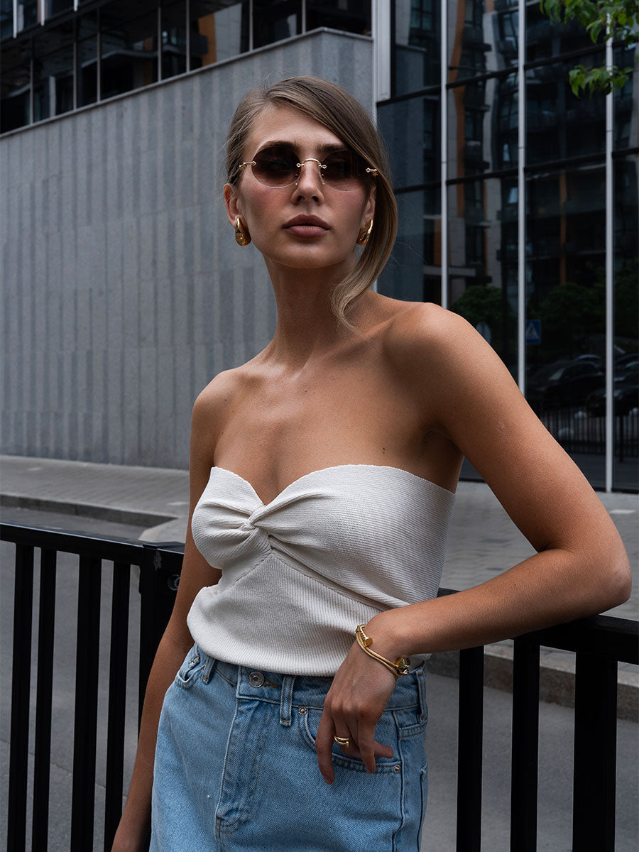 Knitted top of milky color with interweaving